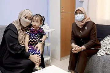 BERI SOKONGAN: Presiden Halimah Yacob (kanan) menemui penerima bantuan di Pusat Khidmat Keluarga Fei Yue, Cik Roziana Ramli dan anaknya, semasa kunjungannya ke sana semalam. - Foto MCI
