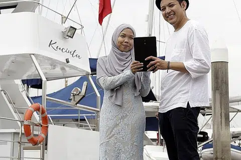 PELUANG KEEMASAN: Promosi langganan membolehkan pembaca menikmati akhbar tradisional BH menerusi tablet sambil berpeluang memenangi hadiah pelayaran bot peranginan berharga $1,850. - Foto BH oleh AZMI ATHNI