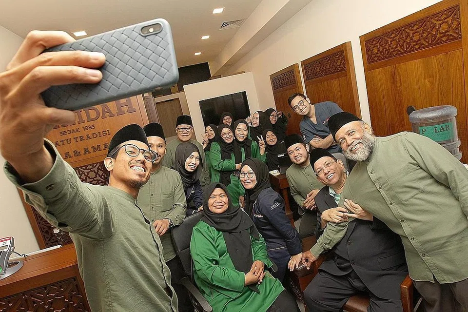 HARGAI SUMBANGAN: Haji Ayoob (duduk, dua dari kanan) melahirkan penghargaannya kepada semua kakitangannya yang banyak membantu beliau membangunkan syarikat beliau selama ini. - Foto BH oleh ZHANG XUAN