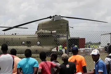 TUNTUT BANTUAN MAKANAN: Puluhan orang muncul di luar kawasan lapangan terbang tempatan meminta makanan setelah helikopter tiba membawa bekalan. - Foto REUTERS