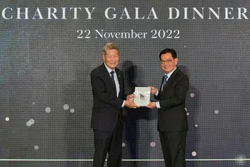 BUKU PERINGATAN: Encik Koh (kiri) menyampaikan buku peringatan kepada Encik Heng sempena ulang tahun ke-70 Persatuan Kanak-kanak Singapura kelmarin. - Foto BH oleh ALPHONSUS CHERN