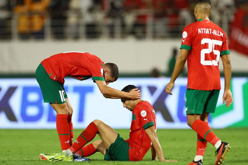 Tunggak sayap Maghribi, Achraf Hakimi (terduduk) dipujuk rakan sepasukan setelah negara itu tewas 0-2 kepada Afrika Selatan dalam perlawanan kalah mati Piala Negara-negara Afrika pada 30 Januari.