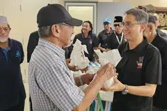 Menteri Negara Kanan (Ehwal Dalam Negeri), Profesor Madya Dr Muhammad Faishal Ibrahim (kanan), mengagihkan bubur dan peket kurma kepada anggota jemaah di Masjid Khalid di Joo Chiat Road pada 1 Mac semasa acara kempen, ‘Dadah Itu Haram’. 