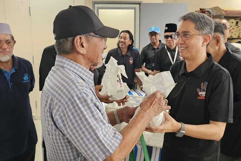 Menteri Negara Kanan (Ehwal Dalam Negeri), Profesor Madya Dr Muhammad Faishal Ibrahim (kanan), mengagihkan bubur dan peket kurma kepada anggota jemaah di Masjid Khalid di Joo Chiat Road pada 1 Mac semasa acara kempen, ‘Dadah Itu Haram’. 