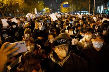 BANTAHAN MELETUS: Penunjuk perasaan (atas) berarak di sepanjang jalan di ibu kota Beijing semasa satu perhimpunan bagi mangsa kebakaran di Xinjiang serta bantahan terhadap sekatan ketat Covid-19 China. - Foto-foto AFP 