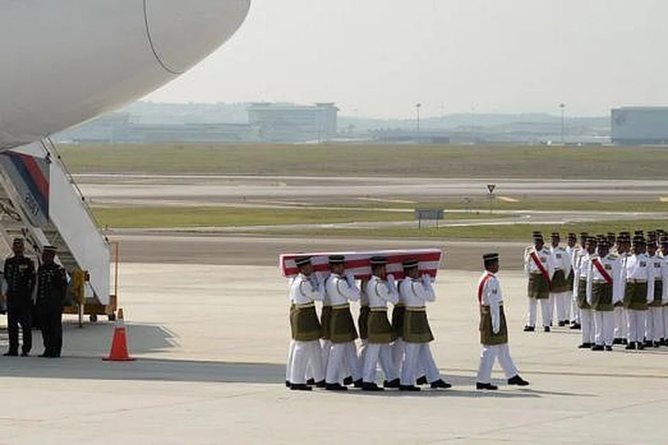 ISTIADAT PENGHORMATAN: Anggota Rejimen Askar Melayu Diraja memberi penghormatan sebelum mengusung keranda mangsa nahas pesawat Malaysia Airlines ketika 'Istiadat Penghormatan Jenazah Tragedi MH17' berlangsung di Lapangan Terbang Antarabangsa Kuala Lumpur. - Foto AFP