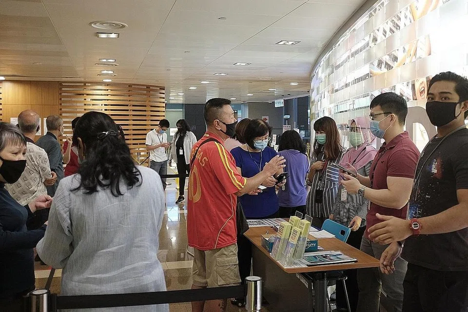 SIBUK: Warga beratur di Hab HDB pada hari pertama selepas sekatan pemutus litar dilonggarkan. Beberapa pejabat awam lain juga kelihatan sibuk dengan warga yang perlu menyambung urusan. - Foto BH oleh JASON QUAH