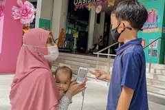 LEBIH MUDAH: Dengan aplikasi 'ShopperLink' yang diperkenalkan HDB, penduduk yang tinggal berdekatan pusat beli-belah Oasis Terraces seperti Cik Nur Hanani Surani (atas) dapat meninjau antara promosi menarik di pusat beli-belah itu sebelum datang secara fizikal ke sana. - Foto BH oleh NUR DIYANA TAHA