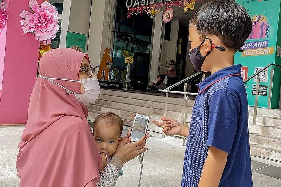 LEBIH MUDAH: Dengan aplikasi 'ShopperLink' yang diperkenalkan HDB, penduduk yang tinggal berdekatan pusat beli-belah Oasis Terraces seperti Cik Nur Hanani Surani (atas) dapat meninjau antara promosi menarik di pusat beli-belah itu sebelum datang secara fizikal ke sana. - Foto BH oleh NUR DIYANA TAHA