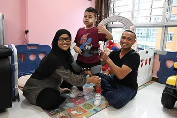 TERUS CEKAL: Pada usia tujuh tahun, Muhammad Mustaqim masih tidak mampu berdiri, berjalan, makan atau tidur sendiri. Kesemua kegiatan asas ini perlu dilakukan dengan bantuan ibunya, Cik Salbiyah dan bapanya Encik Hazrin. - Foto BM oleh KHALID BABA