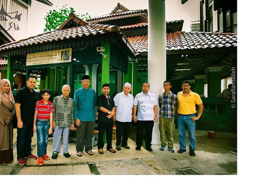 KEUNIKAN MASJID KAMPONG SIGLAP: Encik Sarafian bergambar bersama keluarga keturunan Tok Lassam di depan bangunan lama Masjid Kampong Siglap (berwarna hijau) yang kini berfungsi sebagai Darul Quran Singapura apabila bangunan masjid baru yang lebih besar dibina. - Foto SARAFIAN SALLEH