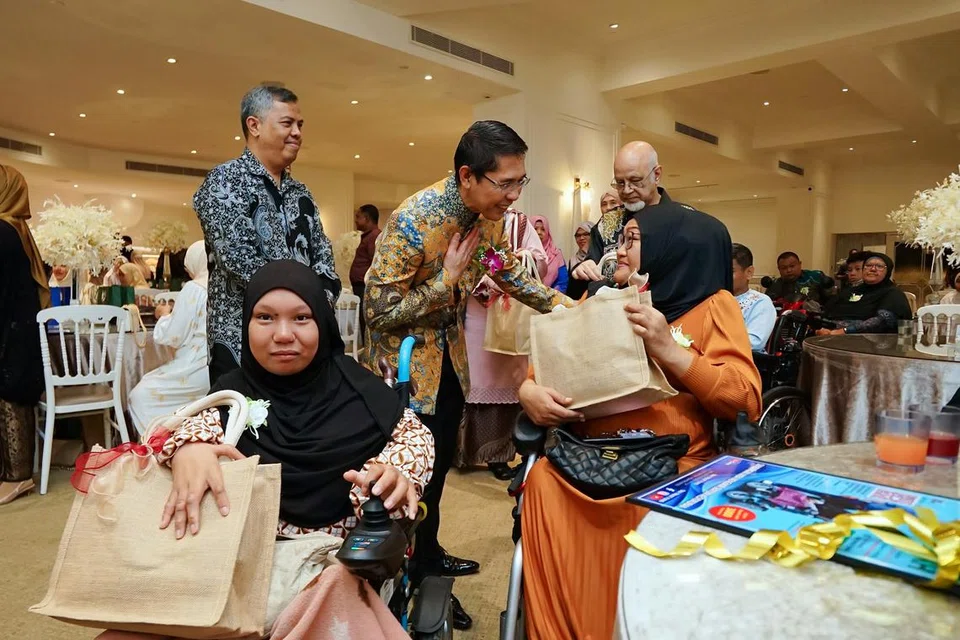Menteri di Pejabat Perdana Menteri, Dr Mohamad Maliki Osman, (berdiri, tengah) ketika beramah mesra bersama seorang penerima habuan TAA, Cik Siti Mazurah Zailan (berbaju jingga) bersama anak perempuannya, Nuralysya (duduk, kiri) disaksikan Ketua Jawatankuasa Eksekutif TAA, (berdiri, kiri) Encik Najib Sahib; dan Pengurus Besar TAA, Encik Mohammad Yahya Zakaria Attia (berdiri, kanan) pada Majlis Pelancaran Kempen Amal TAA-Ramadan 8 Mac lalu. 