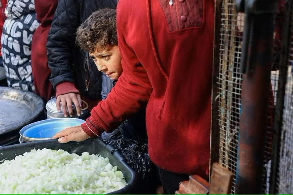 AGIHAN MAKANAN: Seorang kanak-kanak Palestin menunggu untuk menerima makanan yang dimasak oleh dapur amal, di tengah-tengah kekurangan bekalan makanan, ketika konflik antara Israel dan Hamas berterusan.