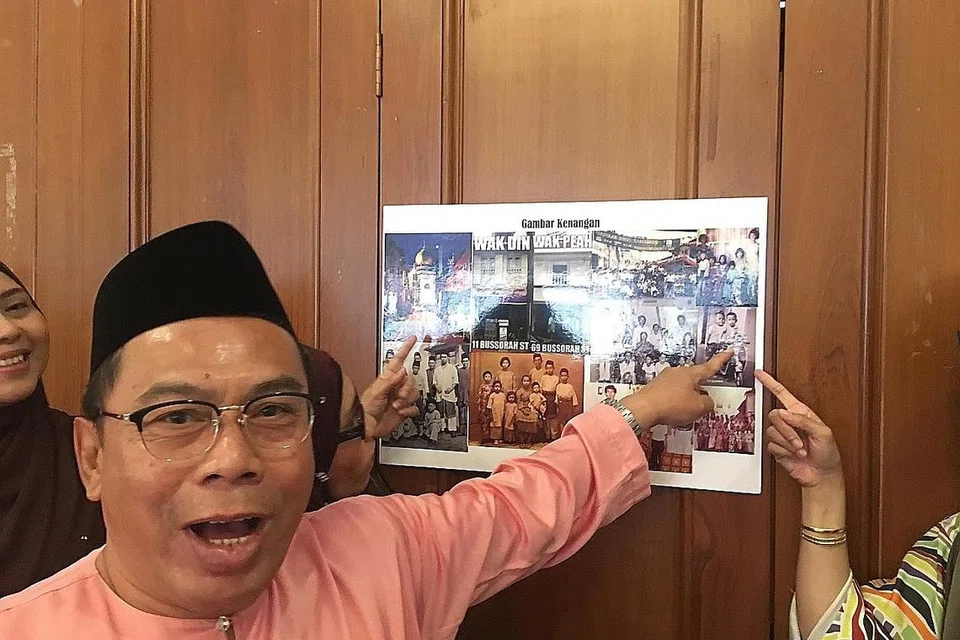 KENANGAN LAMA: Encik Hanafi Hafidz, bekas penduduk Kampong Dalam atau Pahang Street, gembira melihat gambar beliau bermain motosikal mainan semasa kanak-kanak. 