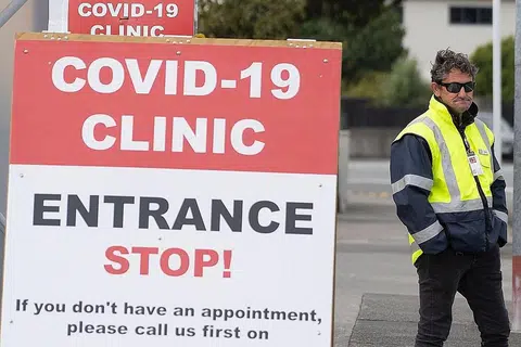 SEDIA AWASI: Foto yang dirakamkan pada 20 April 2020 menunjukkan seorang pengawal keselamatan berjaga di luar klinik koronavirus di Lower Hutt, dekat Wellington, New Zealand. - Foto AFP