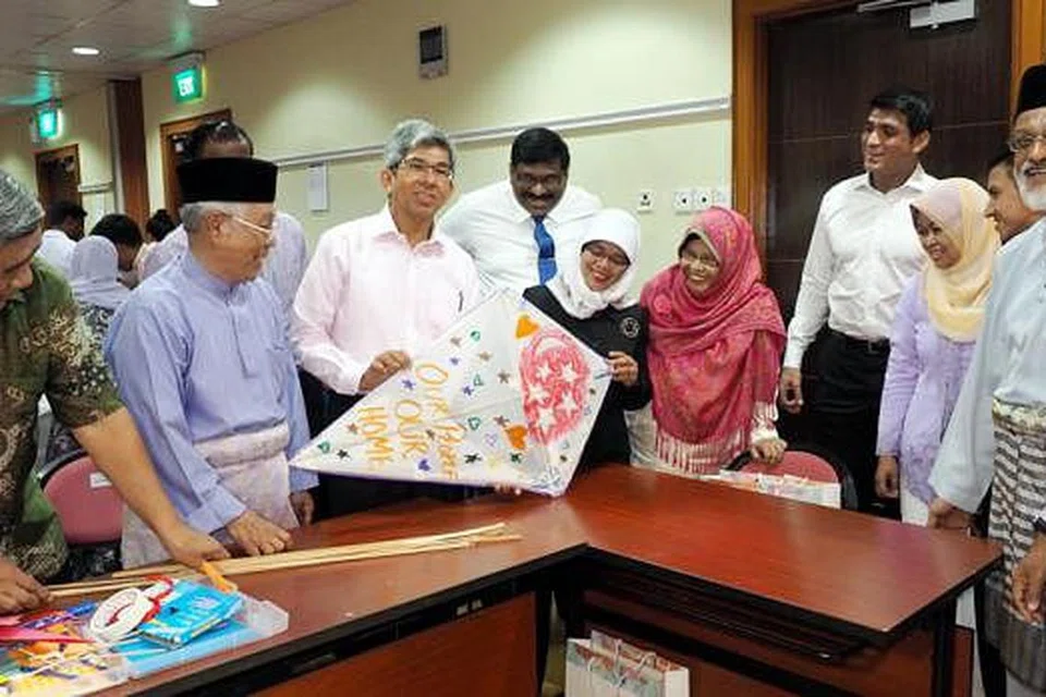 RAI ULANG TAHUN SINGAPURA: Dr Yaacob Ibrahim (tiga dari kiri) dan Cik Halimah Yacob (berbaju hitam) menyertai tetamu acara sambutan Hari Kebangsaan anjuran Yayasan Mendaki seperti mantan Anggota Parlimen (AP) Encik Ibrahim Othman (kiri) dan Mejar Abbas Abu Amin (dua dari kiri) dalam peraduan membuat wau. - Foto JOHARI RAHMAT