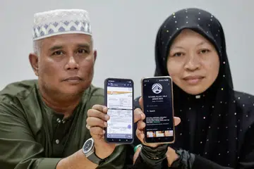 Amir, atau nama sebenarnya, Mohd Azmir Muhammad Yusof (kiri), 56 tahun, berkata beliau agak terkilan selepas penantian sekian lama menunaikan ibadah haji berakhir dengan kedukaan. Bersamanya ialah isterinya, Cik Sarimah Ahmad, 51 tahun, yang sepatutnya berangkat bersama pada 1 Jun lalu.