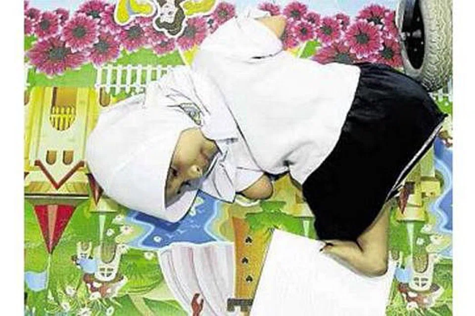 SEMANGAT KENTAL: Nur Damia Irsalina tidak mempunyai kedua-dua belah tangan dan kaki kiri. Dia menulis mengguna kaki kanan pada hari pertama persekolahannya kelmarin. - Foto BERITA HARIAN MALAYSIA