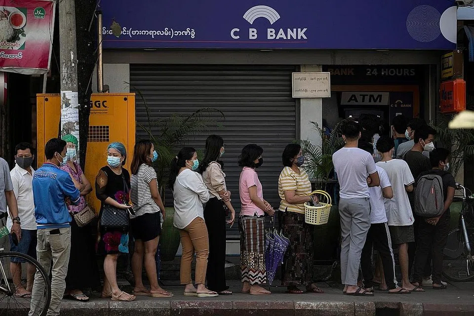 HADAPI PERINTAH DARURAT: Orang ramai beratur bagi mengeluarkan wang di bank di Yangon, ibu kota komersial Myanmar. - Foto REUTERS 