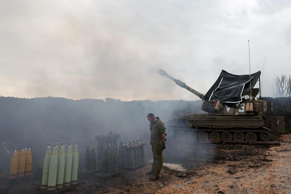 Seorang askar Israel berdiri di samping unit artileri mudah alih di sempadan Israel-Lebanon di utara Israel.