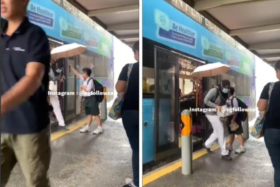 BANTU PENUMPANG: Seorang pelajar kelihatan memegang payung bagi penumpang yang sedang turun dari bas dipercayai di perhentian bas sebelum Punggol Road di TPE.