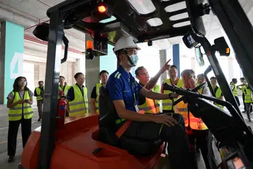 Menteri Negara Kanan (Pertahanan merangkap Tenaga Manusia), Encik Zaqy Mohamed (di kiri pengendali forklift) semasa lawatan tapak ke syarikat logistik Nippon Express pada 27 Mac.