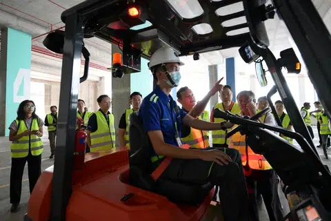 Menteri Negara Kanan (Pertahanan merangkap Tenaga Manusia), Encik Zaqy Mohamed (di kiri pengendali forklift) semasa lawatan tapak ke syarikat logistik Nippon Express pada 27 Mac.
