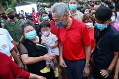 TETAMU ISTIMEWA: Para pengunjung ghairah dengan kehadiran Perdana Menteri, Encik Lee Hsien Loong (dua dari kanan) di karnival sempena Hari Kebangsaan di Taman Bishan-Ang Mo Kio. - Foto BM oleh FELINE LIM