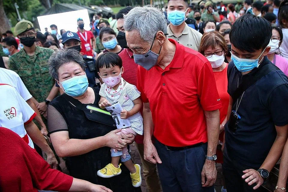 TETAMU ISTIMEWA: Para pengunjung ghairah dengan kehadiran Perdana Menteri, Encik Lee Hsien Loong (dua dari kanan) di karnival sempena Hari Kebangsaan di Taman Bishan-Ang Mo Kio. - Foto BM oleh FELINE LIM