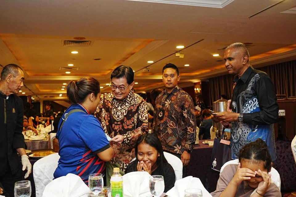 Timbalan Perdana Menteri, Encik Heng Swee Keat (berdiri, tiga dari kanan), beramah mesra dengan penerima bantuan Pertapis semasa majlis berbuka puasa anjuran persatuan itu yang diadakan di Orchid Country Club (OCC) pada 17 Mac. Bersamanya ialah Presiden Pertapis, Encik Mohamed Shaharin Mohamed Nordin (kanan). 