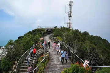 DIBANJIRI: Pelancong membanjiri Langkawi termasuk pelbagai tarikan seperti di Pantai Chenang dan Kereta Kabel Gunung Machincang. - Foto AFP