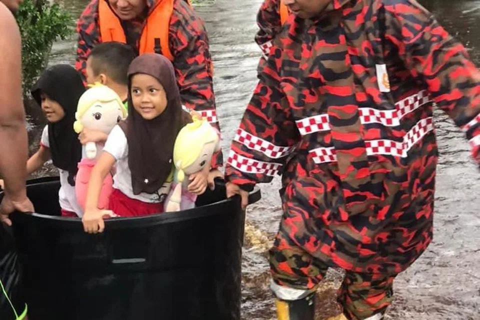 BANTU SELAMATKAN: Anggota Jabatan Bomba dan Penyelamat Malaysia menyelamatkan mangsa yang terperangkap di kediaman dalam kejadian banjir kilat di kira-kira 25 lokasi di Johor Bahru pada 6 Disember. 