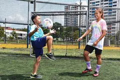 MAHU ASAH POTENSI PELAJAR AUTISME: Cik Ernie (kanan) mengajar seorang pelajar Singa Champs, Muhamad Ruzaiman Muhamad Rosli, sembilan tahun, cara untuk menimbang bola. - Foto BH oleh DESMOND WEE dan FACEBOOK ERNIE SONTARIL