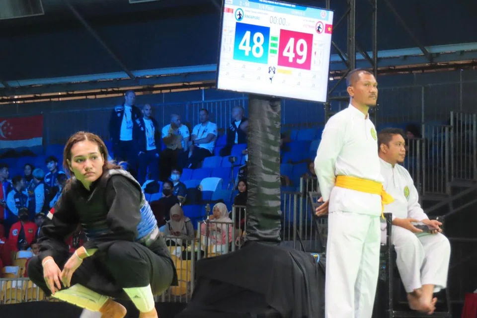 LANGKAH KIRI: Suhaila (paling kiri) ketika menunggu keputusan selepas jurulatih Singapura membuat bantahan terhadap penilaian wasit yang dianggap tidak tepat. - Foto BH oleh ZULAIQAH ABDUL RAHIM 