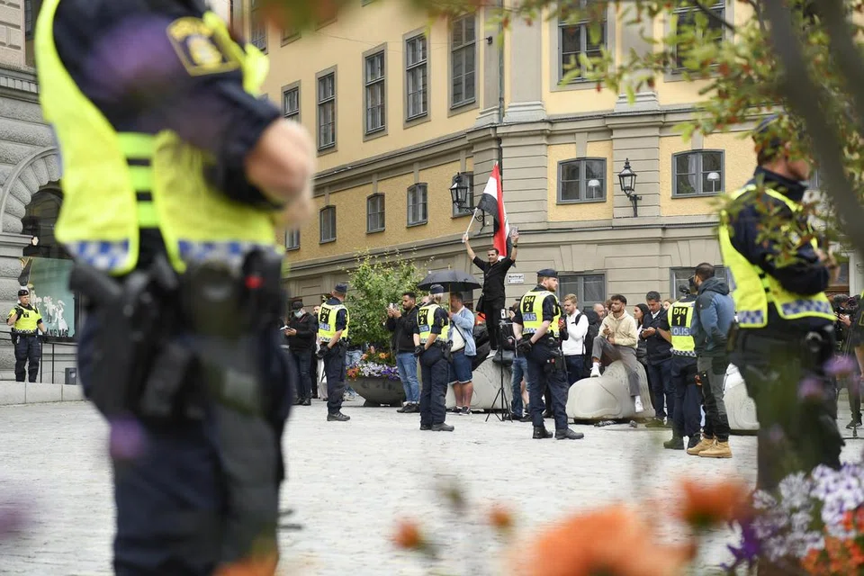 BERJAGA-JAGA: Para pegawai polis diletakkan dalam keadaan berjaga-jaga ketika seorang lelaki cuba membakar Al-Quran dalam satu demonstrasi di Mynttorget, Stockholm, Sweden pada 31 Julai. 