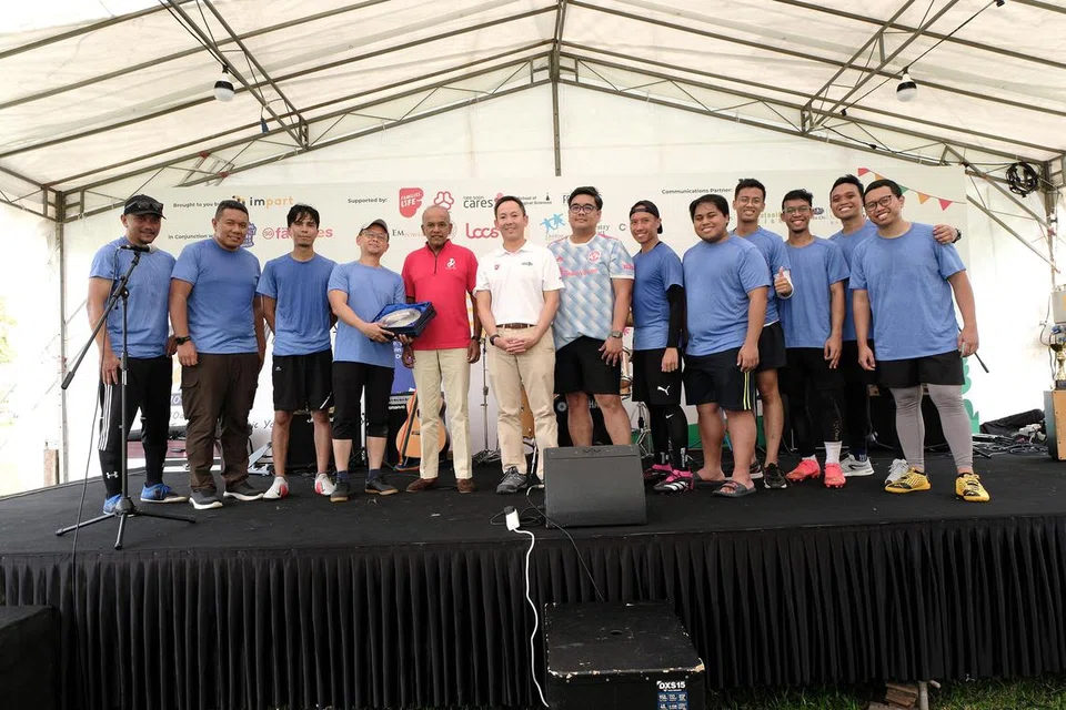 BERI SOKONGAN: Kapten pasukan Berita Harian, Farid Hamzah (empat dari kiri) bergambar bersama pasukan, serta tetamu terhormat, Menteri Ehwal Dalam Negeri merangkap Undang-Undang, Encik K. Shanmugam (lima dari kiri). BH sertai acara dalam perlawanan persahabatan dengan pasukan Bapa Sepanjang Hayat.  