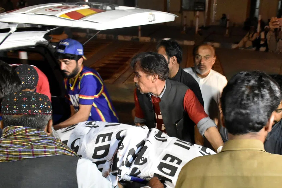 DAPATKAN RAWATAN: Orang ramai dan pegawai perubatan membawa mayat keluarga penganut Kristian yang dibunuh lelaki bersenjata di Quetta, Pakistan - Foto REUTERS
