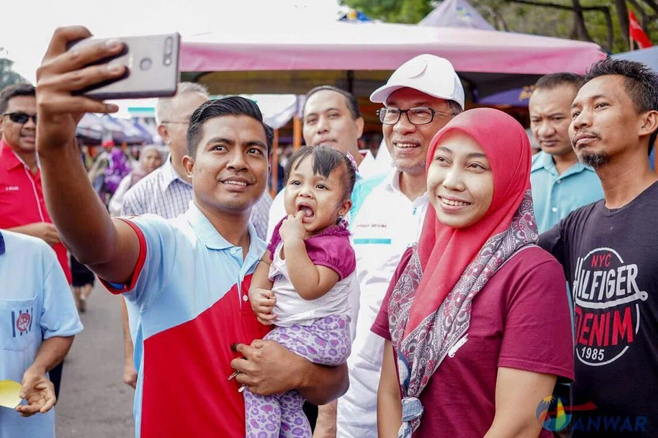 BERAMAH MESRA: Datuk Anwar (tengah dan bertopi) sempat menyapa para pengundi semasa mengunjungi peniaga Pasar Tani Batu 4, Bagan Pinang, Port Dickson, pagi semalam. - Foto TWITTER ANWAR IBRAHIM