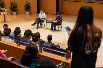 Pemangku Menteri Kebudayaan, Masyarakat dan Belia, Encik David Neo (atas pentas, kiri), mendengar soalan dari seorang belia semasa sesi dialog di Persidangan HarmonyWorks! yang diadakan di Pusat Kebudayaan Republic di Politeknik Republic pada 12 Julai. Bersama beliau di pentas ialah moderator dan pengerusi jawatankuasa penganjur persidangan itu, Encik Hafez Zanjani.