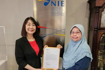 TERIMA PELANTIKAN: Profesor Madya Hadijah Rahmat menerima surat pelantikan jawatan Profesor Madya Emeritus daripada Pengarah Institut Pendidikan Nasional (NIE), Profesor Christine Goh.