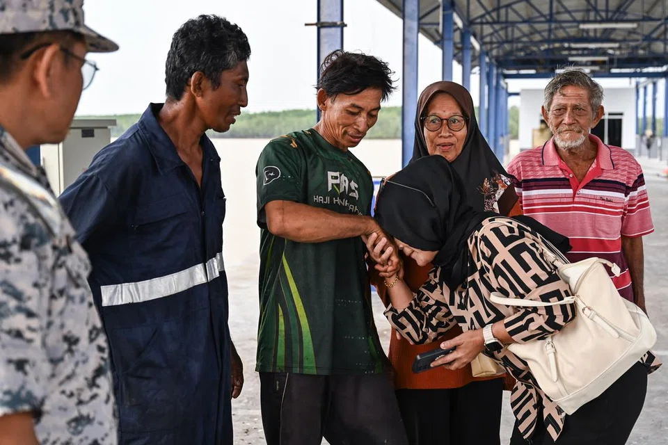 Tiga nelayan, Encik Mohd Nasir Yusoff (dua, kiri), Encik Syukri Mokhtar (tiga, kiri) dan Encik Mokhtar Yusoff (kanan) disambut ahli keluarga selepas dibawa pulang susulan dikhuatiri hilang selepas keluar memancing.