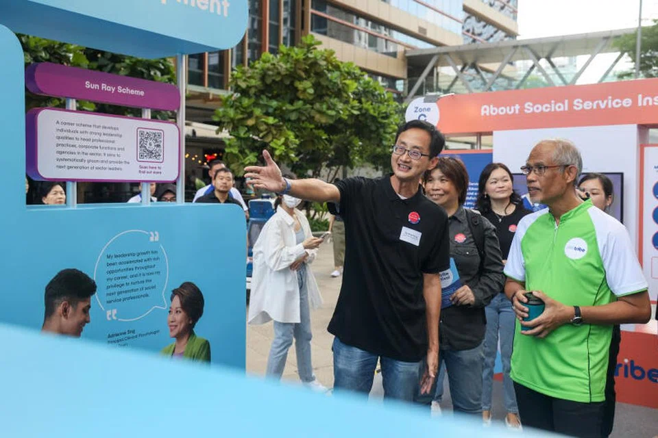 Encik Masagos Zulkifli Masagos Mohamad (kanan) melihat pameran di Pesta Komuniti Perkhidmat Sosial yang diadakan di Paya Lebar Quarter Plaza.