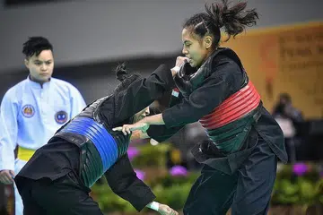 TENANG TAPI MENYENGAT: Nadhrah (kanan) ketika beraksi dalam final acara tanding puteri A (45-50 kilogram) senior di Kejohanan Pencak Silat Asia Tenggara Ahad lalu. - Foto-foto BH oleh ARIFFIN JAMAR