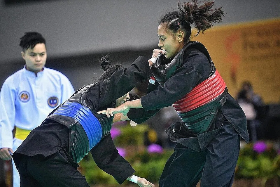 TENANG TAPI MENYENGAT: Nadhrah (kanan) ketika beraksi dalam final acara tanding puteri A (45-50 kilogram) senior di Kejohanan Pencak Silat Asia Tenggara Ahad lalu. - Foto-foto BH oleh ARIFFIN JAMAR