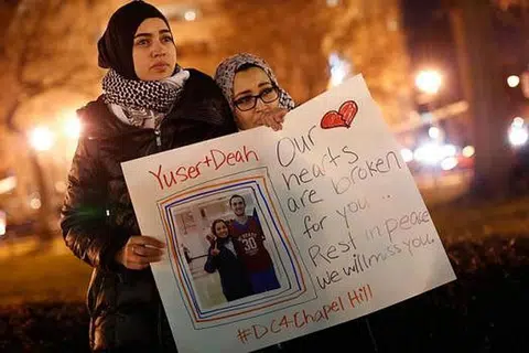 BERI SOKONGAN: Cik Kheira Benkreira (kiri) dan Cik Hasnia Bekkadja memberi sokongan sewaktu perhimpunan di Washington semalam sebagai memperingati tiga pelajar Muslim yang ditembak mati oleh jiran mereka. - Foto AFP