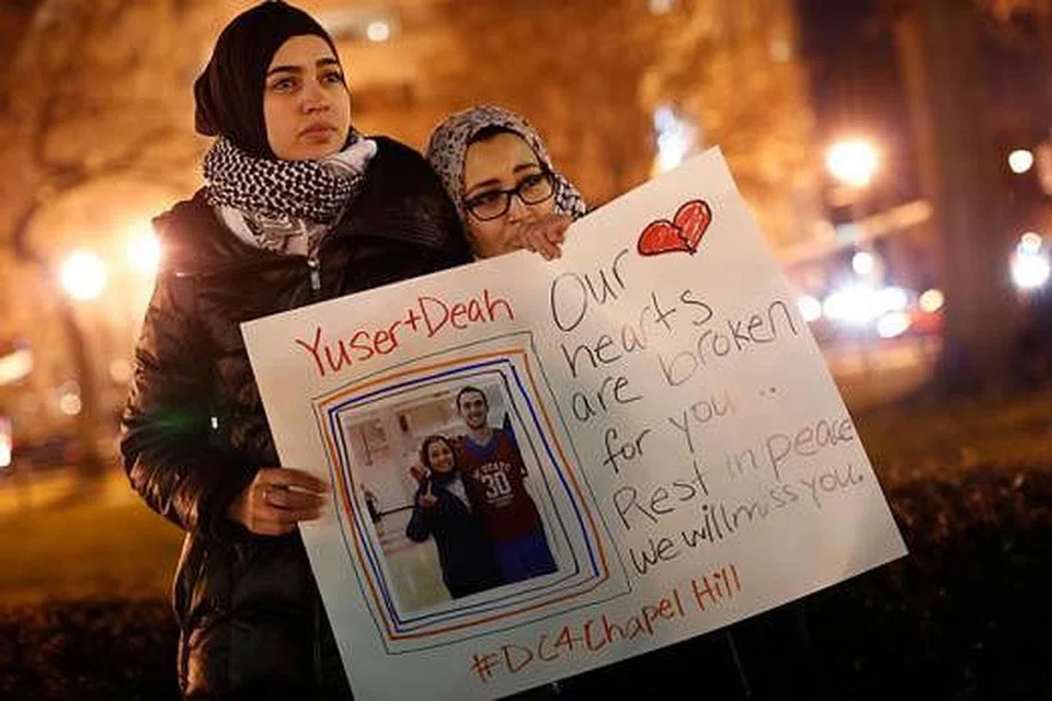 BERI SOKONGAN: Cik Kheira Benkreira (kiri) dan Cik Hasnia Bekkadja memberi sokongan sewaktu perhimpunan di Washington semalam sebagai memperingati tiga pelajar Muslim yang ditembak mati oleh jiran mereka. - Foto AFP