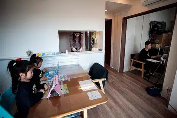 PELBAGAI KEGIATAN TERTUMPU DI RUMAH: Encik Yuki Sato, yang bekerja dengan sebuah firma baru, cuba memberi tumpuan pada tugas apabila diarah bekerja dari rumah sedang isterinya sibuk menyiapkan sajian di dapur dan anak-anak mereka membuat kerja sekolah. - Foto AFP