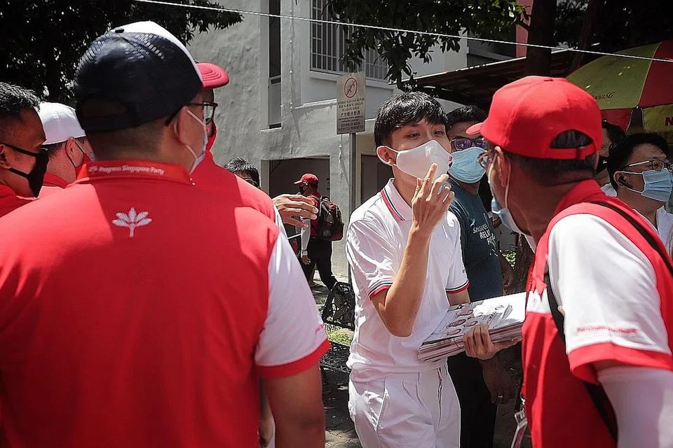 BOLEH AKIBATKAN JANGKITAN: Sukarelawan Parti Tindakan Rakyat (PAP) dan Parti Kemajuan Singapura (PSP) melaungkan slogan parti mereka terhadap satu sama lain apabila bertembung di depan kedai kopi Blok 848, Yishun Ring Road, kelmarin. - Foto BH oleh GAVIN FOO