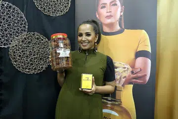 JANGAN MERENDAHKAN PILIHAN ORANG: Haiza yang turut berniaga barangan jenama MyHaiza dan kudapan cakar ayam rangup, berharap sesiapa pun tidak akan memandang rendah pada muzik dangdut. - Foto BH oleh PUTRI MARDHIYAH YAZID