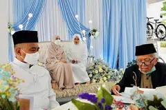 SUASANA SANTAI: Encik Azman (kiri) memilih mengadakan majlis walimahnya di kolong blok 241 Jurong East semasa berkahwin dengan isterinya, Cik Nurul Aini, Mei lalu. - Foto ihsan AZMAN SULAIMAN
